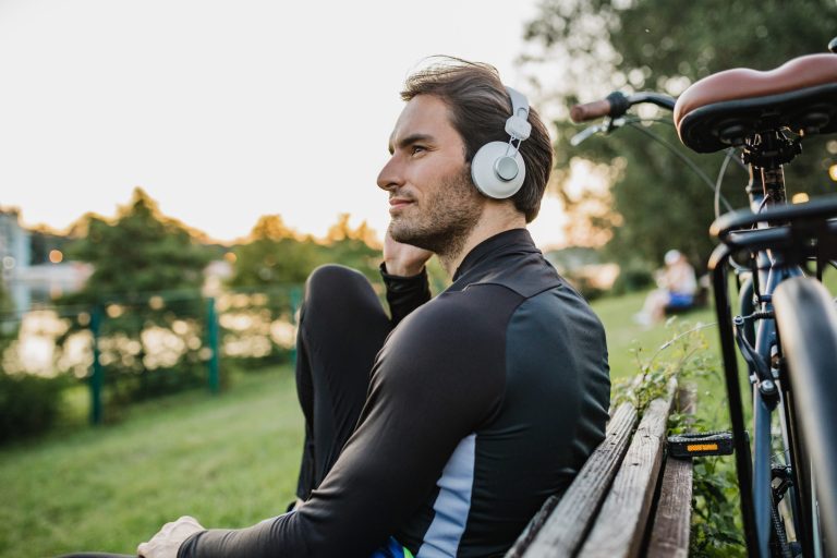 Der junge Mann trägt Sportkleidung und entspannt sich beim Radfahren beim Sonnenuntergang