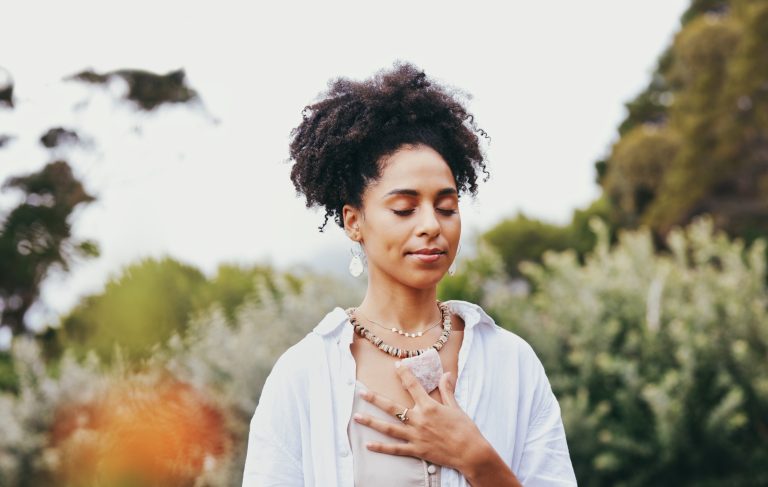 Chakra, Frau und spiritueller Hippie meditieren für Frieden, Harmonie und Ruhe draußen in der Natur oder im Park. Jung, Entspannung und Wohlbefinden durch eine Frau, die ihre Seele und ihr Herz mit einem Edelstein heilt